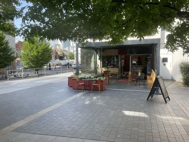 The shopfront on the square, with tables outside under the trees