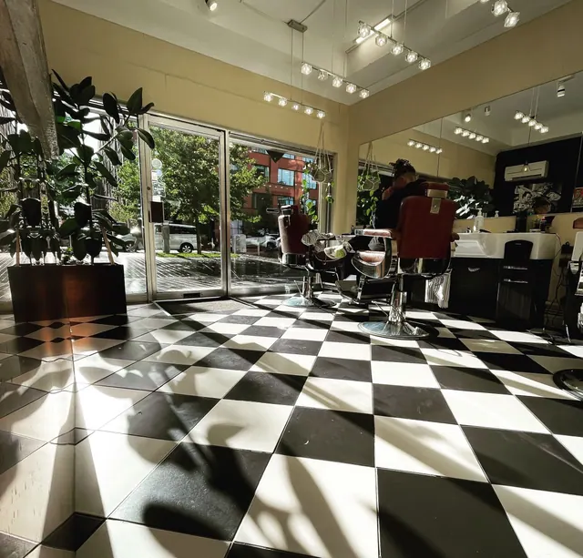 Inside: a barber chair on the black and white chequered floor, plants by the window