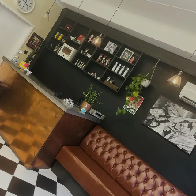 The waiting area: a leather sofa, shelves and framed prints