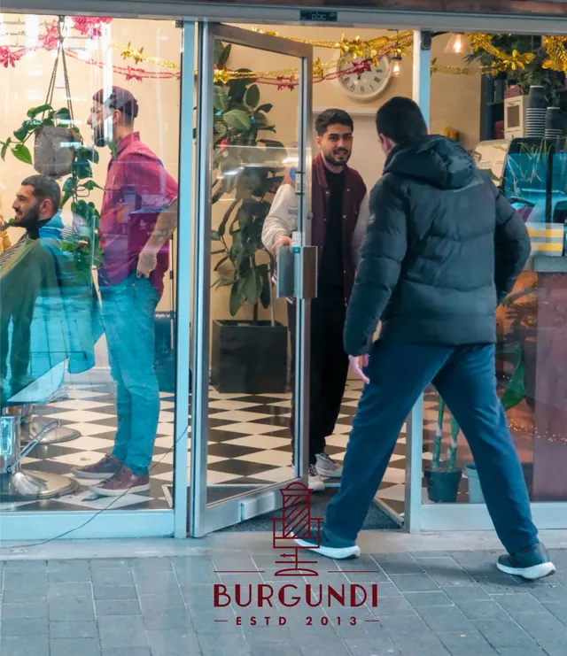 The glass entrance, a barber at work inside